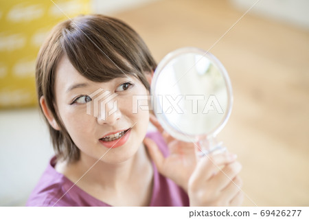 年輕女子在家裡化妝 年輕女子在家裡化妝 69426277