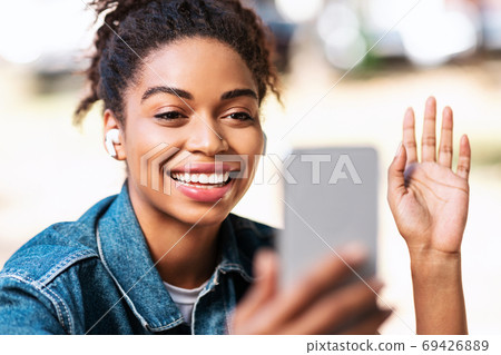African Girl Making Video Call Using Phone Waving Hello Outdoors 69426889