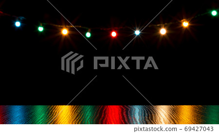 Colorful christmas lights reflection on wooden table and bokeh o 69427043
