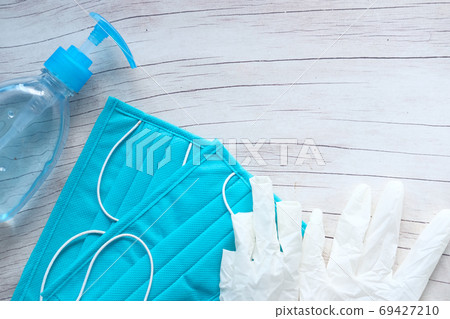 Surgical masks and hand sanitizer on green background  69427210