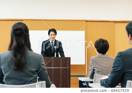 Man speaking at a lecture Man speaking at a lecture 69427429