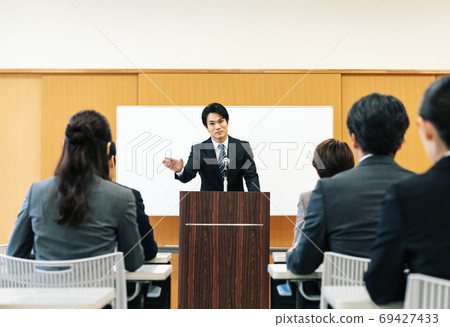 Man speaking at a lecture 69427433