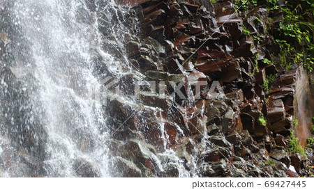 Rocks shining in the water of a waterfall Rocks shining in the water of a waterfall 69427445