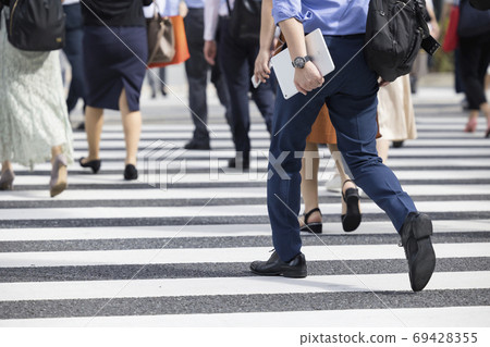 A businessman crossing a pedestrian crossing A businessman crossing a pedestrian crossing 69428355