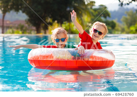 Kids in swimming pool. Life jacket for child. 69428760