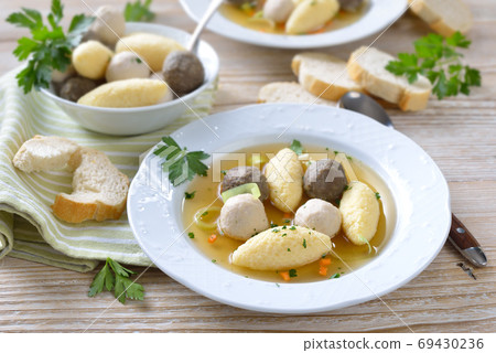 Delicious wedding soup consisting of a strong meat broth with various small dumplings Delicious wedding soup consisting of a strong meat broth with various small dumplings 69430236