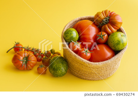 Basket with a variety of tomatoes, including 69430274