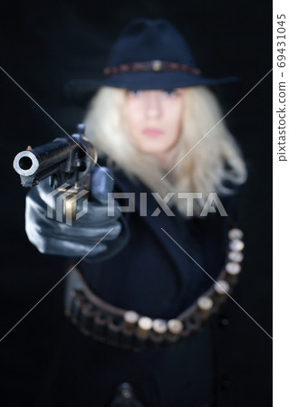 wild west blonde girl wearing black hat shooting from revolver wild west blonde girl wearing black hat shooting from revolver 69431045
