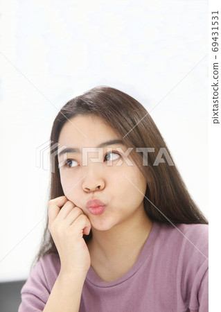 A young woman looking up with a sharp mouth 69431531