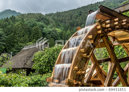 The mill wheel rotates under a stream of water, open air museum, Japan. The mill wheel rotates under a stream of water, open air museum, Japan. 69431851