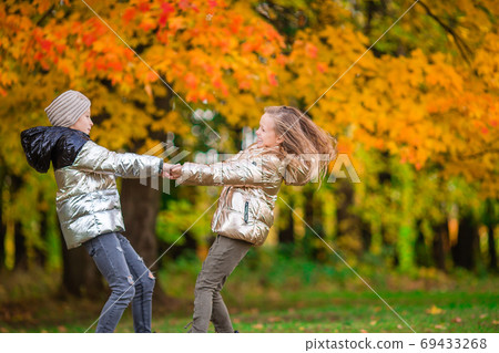 Little adorable girls at warm sunny autumn day outdoors 69433268