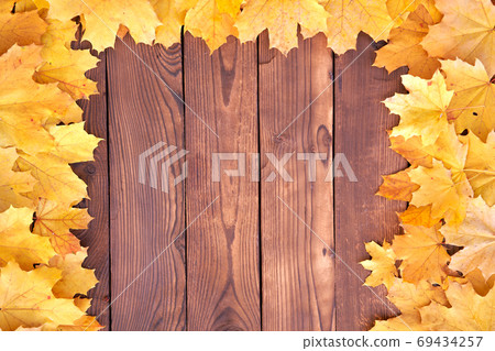 Autumn leaves frame on wooden background top view 69434257