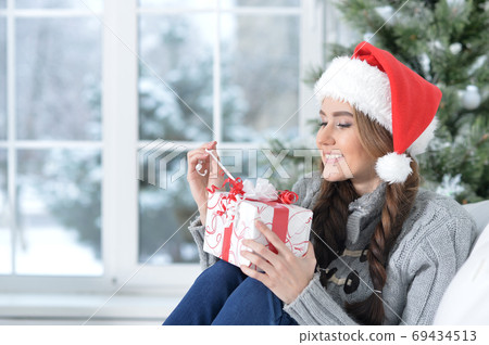 Portrait of smiling woman with Christmas gift Portrait of smiling woman with Christmas gift 69434513
