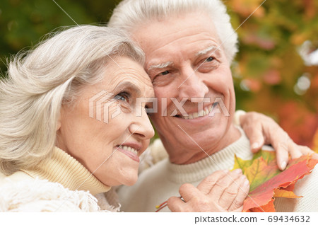 Portrait of beautiful senior couple with leaves in the park Portrait of beautiful senior couple with leaves in the park 69434632