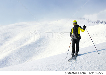 Skier standing on mountain slope Skier standing on mountain slope 69436227