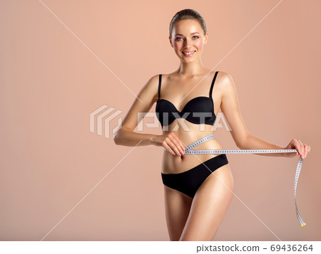 Premium Photo  Keeping her body in shape. beautiful young woman in sports  clothing holding apple and measuring tape and smiling while standing  isolated on white