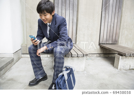 High school boys looking at smartphones 69438038