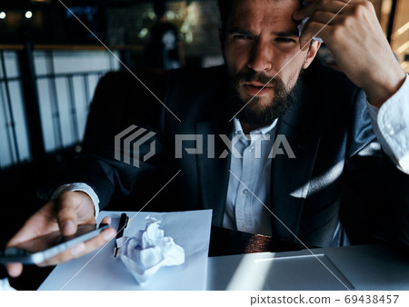 business man sitting at table in front of laptop crumpled paper lifestyle executive job technology business man sitting at table in front of laptop crumpled paper lifestyle executive job technology 69438457