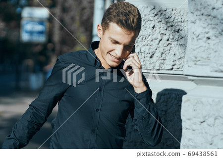 Business man in a shirt near the building with documents in his hands 69438561