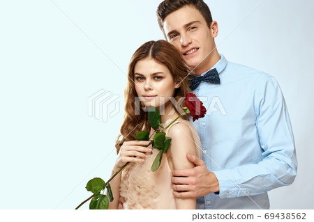 Cheerful young couple romance embrace relationship red rose lifestyle light background Cheerful young couple romance embrace relationship red rose lifestyle light background 69438562