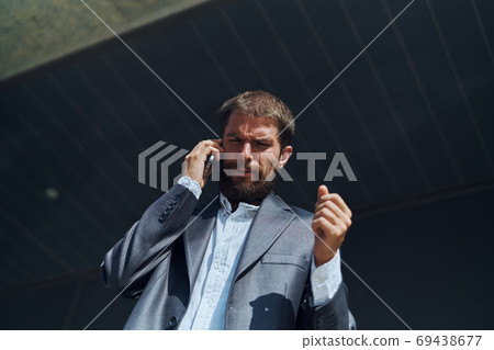 business man in a suit talking on the phone outdoors business manager executive 69438677