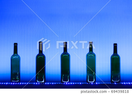 abstract empty wine bottles with blue led illumination 69439818