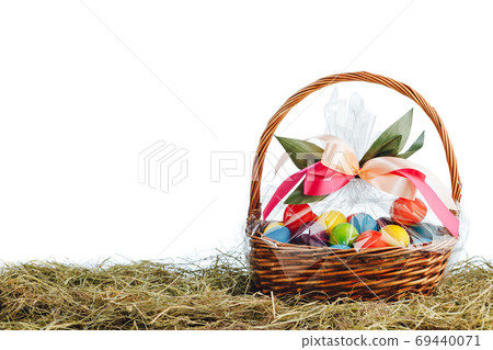 Easter gift basket with multicolor eggs, white background Easter gift basket with multicolor eggs, white background 69440071