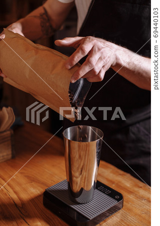 man is using coffee beans for good coffee man is using coffee beans for good coffee 69440103