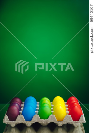 Easter festive multicolor eggs carton, green background Easter festive multicolor eggs carton, green background 69440107