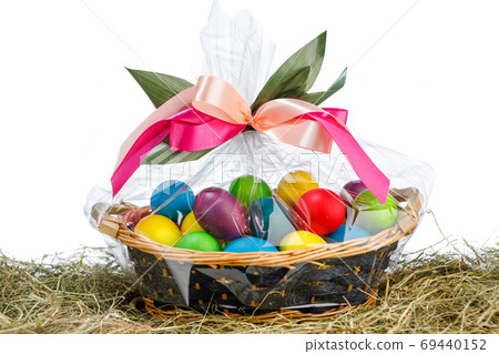 Easter gift basket with multicolor eggs, white background 69440152