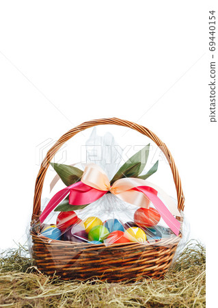 Easter gift basket with multicolor eggs, white background Easter gift basket with multicolor eggs, white background 69440154