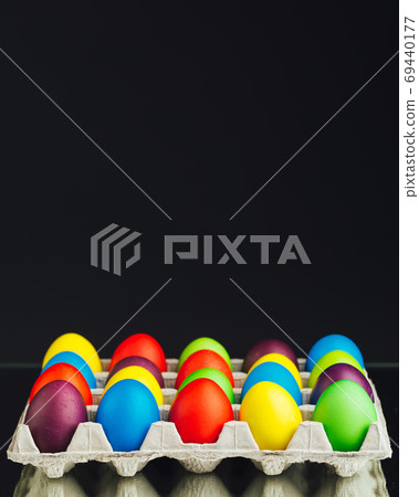 Easter festive multicolor eggs carton, black background Easter festive multicolor eggs carton, black background 69440177