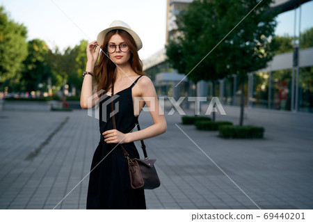 fashionable woman on city street in black dress and hat glasses makeup model watch on hand fresh air 69440201