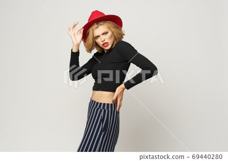 Fashionable woman in red hat black blouse red lips cropped view light background emotions Fashionable woman in red hat black blouse red lips cropped view light background emotions 69440280
