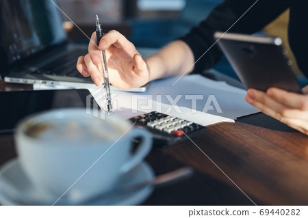 Laptop keyboard female hands work freelance office model documents calculator. Laptop keyboard female hands work freelance office model documents calculator. 69440282