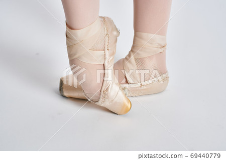 Ballerina in a white tutu dance performed on a light background Ballerina in a white tutu dance performed on a light background 69440779