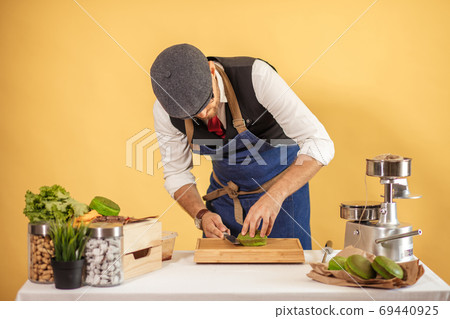 Man cuttung green bun for making burger indoors, food and small business concept 69440925