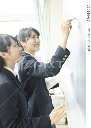 High school girls writing on the blackboard 69441411