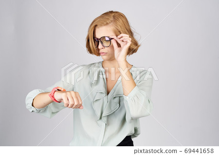 Fashionable woman with a pink watch on her hand on a light background Fashionable woman with a pink watch on her hand on a light background 69441658