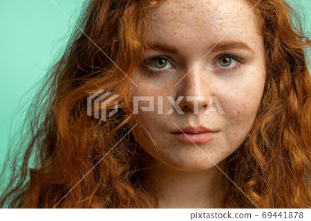 Close-up of beautiful red-haired freckled girl with loose curly hair 69441878