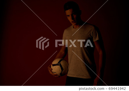 man with soccer ball on dark background in t-shirt, cropped view man with soccer ball on dark background in t-shirt, cropped view 69441942
