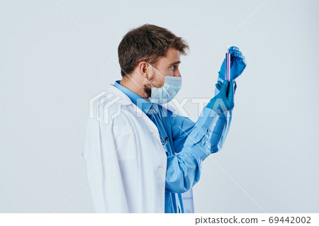 male doctor in a medical gown mask gloves laboratory research liquid virus vaccine 69442002