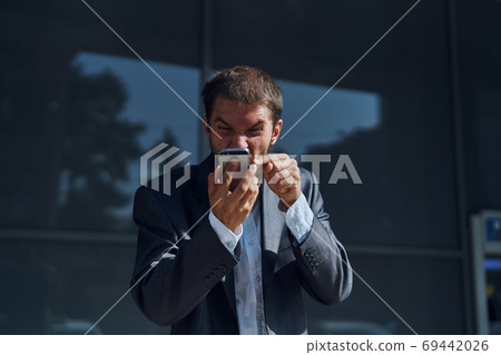 Business man communicates on the phone outdoors emotions executive manager lifestyle Business man communicates on the phone outdoors emotions executive manager lifestyle 69442026