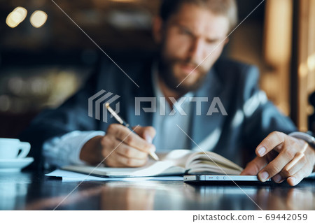 business man sitting at a table in a cafe documents work official coffee cup business man sitting at a table in a cafe documents work official coffee cup 69442059