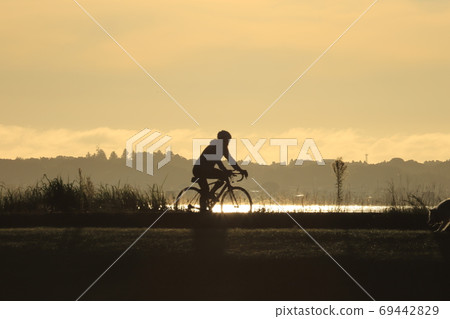A cyclist running on the Tsukuba Kasumigaura Rinrin Road in the early morning 69442829