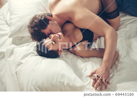Top view of sexy undressed couple embracing and kissing in bed 69443180