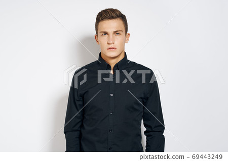Man in black shirt lifestyle emotions modern style cropped view light background 69443249