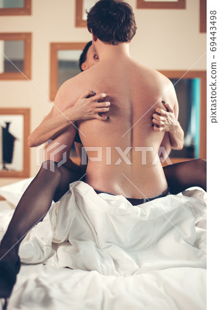 Sexy young couple kissing and playing in bed. Sexy young couple kissing and playing in bed. 69443498