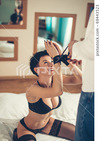 Young couple in bdsm action on the leather sofa 69443523