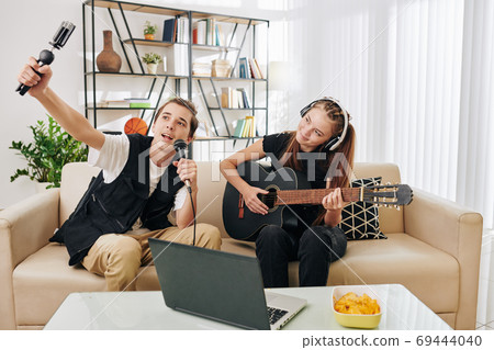 Teenager filming themselves singing Teenager filming themselves singing 69444040